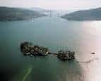 Vista aérea de las Islas de San Simón y San Antón unidas por un puente, con el Puente de Rande a lo lejos