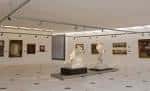 Galería de arte interior con cuadros y esculturas