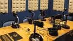 Mesa de estudio de radio con varios micrófonos y auriculares