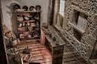 Sala de exposición en la Casa Museo María Pita con estanterías de cerámica y objetos antiguos