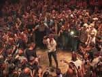 Artista interactuando con el público en el escenario durante un concierto