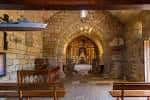 Interior de la Ermita de La Lanzada con altar y bancos de madera