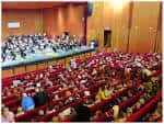 Interior del auditorio con orquesta en el escenario y público