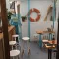 Zona interior con mesas altas, taburetes y decoración temática
