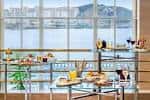 Mesa de buffet con variedad de alimentos y vistas al mar