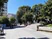 Acceso arbolado a la Plaza de España con bancos y zonas verdes