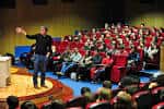 Interior de un auditorio o sala de conferencias con público y un ponente
