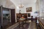 Salón interior del convento con mobiliario clásico, alfombra y lámpara de araña