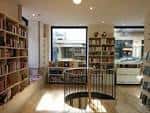 Interior de la librería de NUMAX con estanterías y escalera de caracol