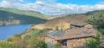 Paisaje de la Ribeira Sacra con el embalse y edificaciones tradicionales.