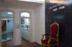 Pasillo interior con silla de terciopelo rojo y panel expositivo