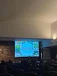 Interior de un auditorio o sala de conferencias con pantalla de proyección