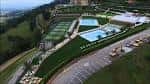Vista aérea del complejo deportivo con piscinas, pistas de tenis y zonas verdes