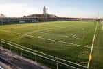 Campo de fútbol principal de la Ciudad Deportiva de la Torre con la Torre de Hércules al fondo