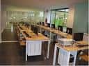 Sala interior del Centro Cívico Los Rosales equipada con mesas, ordenadores y proyector