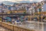 Río Mandeo con embarcaciones y la arquitectura de Betanzos al fondo.