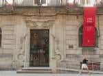 Entrada principal de la Casa da Cultura Salvador de Madariaga con estandarte rojo
