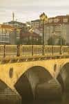 Primer plano del Puente del Burgo al atardecer con edificios al fondo