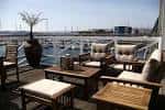 Terraza exterior con mobiliario lounge y vistas al puerto deportivo