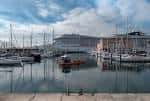 Marina del Real Club Náutico de La Coruña con barcos y un gran buque al fondo.