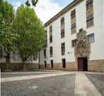 Fachada principal de la Facultade de Filosofía y patio pavimentado