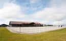 Vista exterior del Centro Hípico Casas Novas con pista de arena y edificio principal