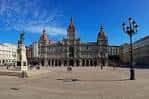 Amplia vista de la Plaza de María Pita con el Ayuntamiento y la estatua bajo un cielo azul