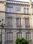 Sección de la fachada de la Escola de Artes e Oficios con ventanas y detalles arquitectónicos