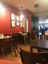Interior del Café Arume con mesas y sillas, mostrando el ambiente acogedor.