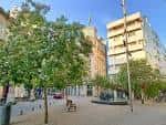 Amplia vista diurna de la Praza de San Xosé con árboles y edificios modernos
