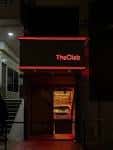 Entrada exterior de The Clab por la noche con el letrero iluminado