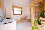 Interior de una sala de spa con sauna, jacuzzi y zona de relax.