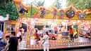 Carrusel clásico en funcionamiento con niños y familias en el Recinto Ferial