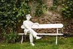Estatua en un banco blanco en el jardín de la Casa Museo