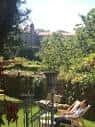 Amplio jardín de la pensión con zonas verdes y vistas a la ciudad