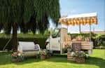 Puesto de bebidas o comida con toldo y decoraciones florales en exterior