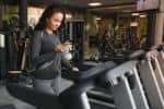 Mujer haciendo ejercicio en una cinta de correr dentro del gimnasio