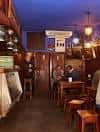 Interior de bar El Pasillo con ambiente íntimo y mesas de madera