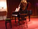 Escenario con piano y cortinas rojas, ideal para eventos