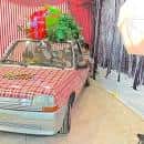Interior de sala de arte con decoración festiva y un coche antiguo