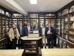 Interior de una antigua farmacia con mobiliario de madera y vitrinas llenas de recipientes