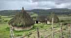 Conjunto de cabañas prehistóricas con paisaje montañoso de fondo
