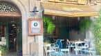 Fachada de un restaurante con toldo verde y mesas al aire libre en Vigo