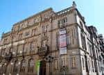 Vista frontal de la Escola Municipal de Artes e Oficios de Vigo bajo un cielo azul