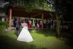 Ceremonia al aire libre bajo una pérgola de madera con una novia.