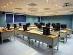 Sala interior de formación o aula de informática con mesas y monitores