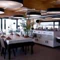 Zona de comedor interior con mesas preparadas y barra de servicio