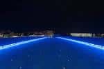 Reflejos de luces azules en el agua cerca del Puente del Burgo por la noche