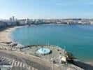 Playa de Riazor y paseo marítimo con la fuente de los surfistas