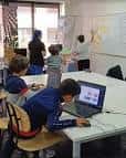 Interior de aula de Kidcode con niños programando en ordenadores